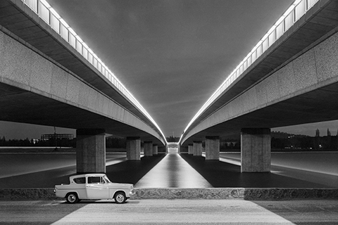 Black and white photo of car passing beneath Commonwealth Avenue Bridge