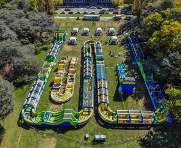 The Tuff Nutterz obstacle course on Parkes Place Lawns, the image features several gigantic inflatable obstacle courses.