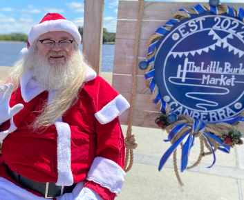 Santa posing with the Little Burley Market Sign